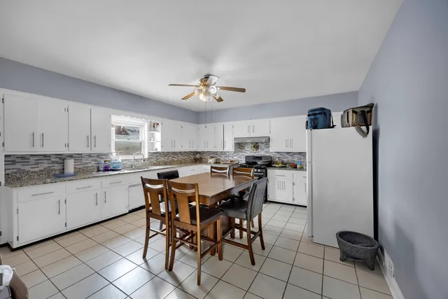 a kitchen with a dining table chairs sink and cabinets