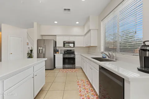 a kitchen with white cabinets and stainless steel appliances