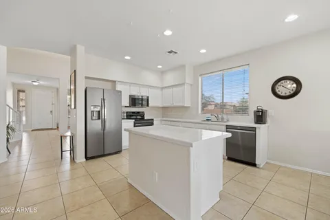 a kitchen with stainless steel appliances granite countertop a refrigerator and a stove top oven