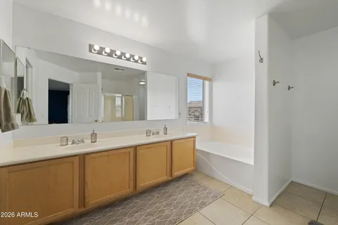 a spacious bathroom with a tub sink and mirror