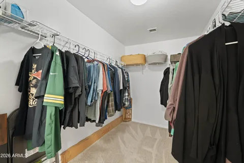a view of walk in closet with clothes and shoes