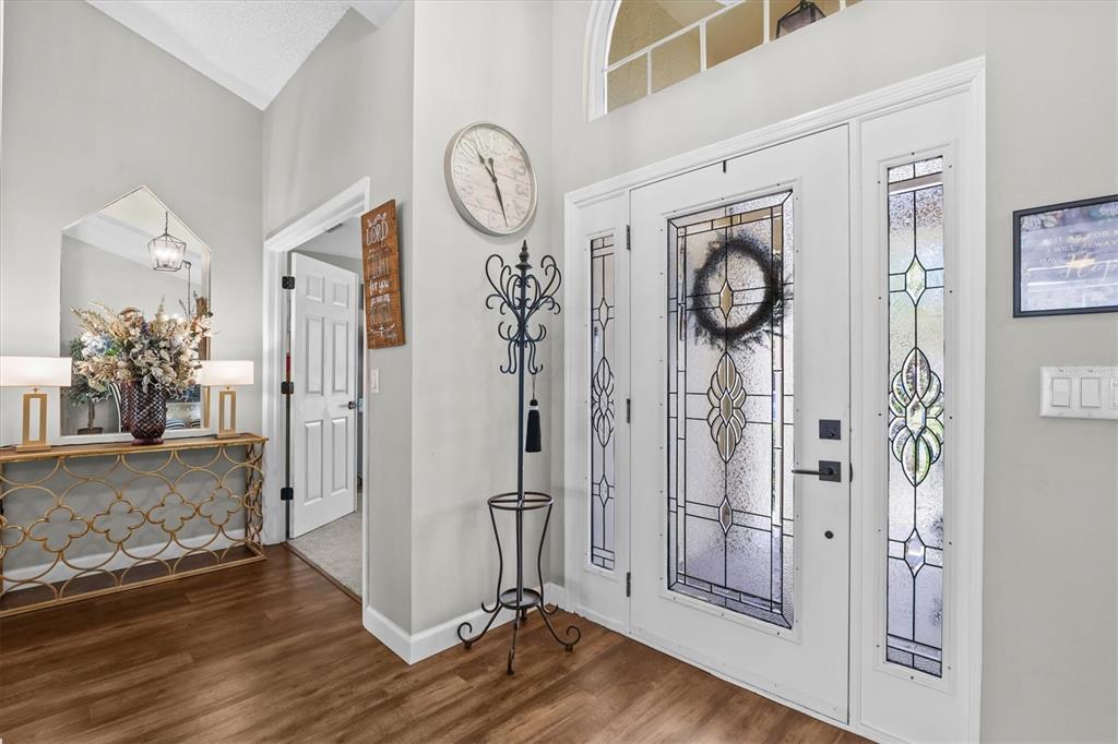 1049 Larkin Road Spring Hill, FL 34608 - Photo 11 of 64 a view of a hallway with wooden floor and a chandelier