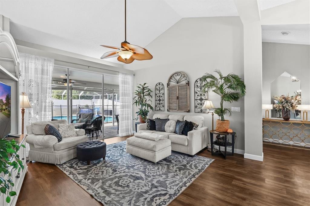 1049 Larkin Road Spring Hill, FL 34608 - Photo 16 of 64 a living room with furniture wooden floor and a chandelier