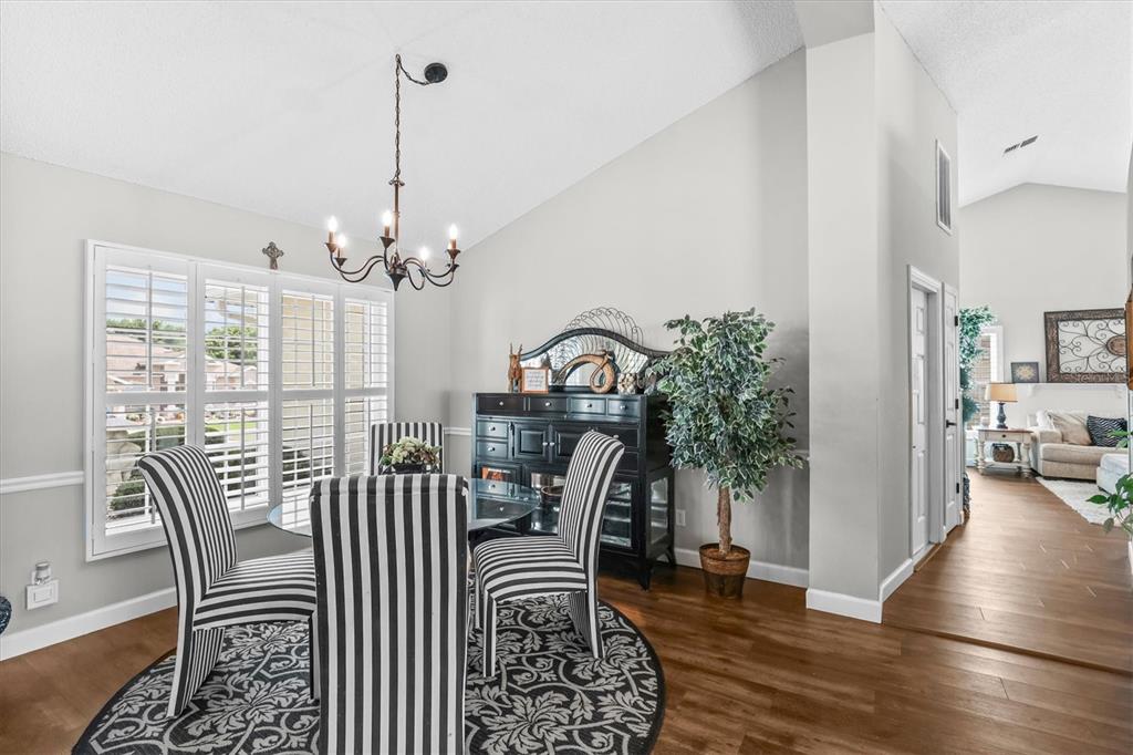 1049 Larkin Road Spring Hill, FL 34608 - Photo 17 of 64 a view of a dining room with furniture wooden floor and a chandelier