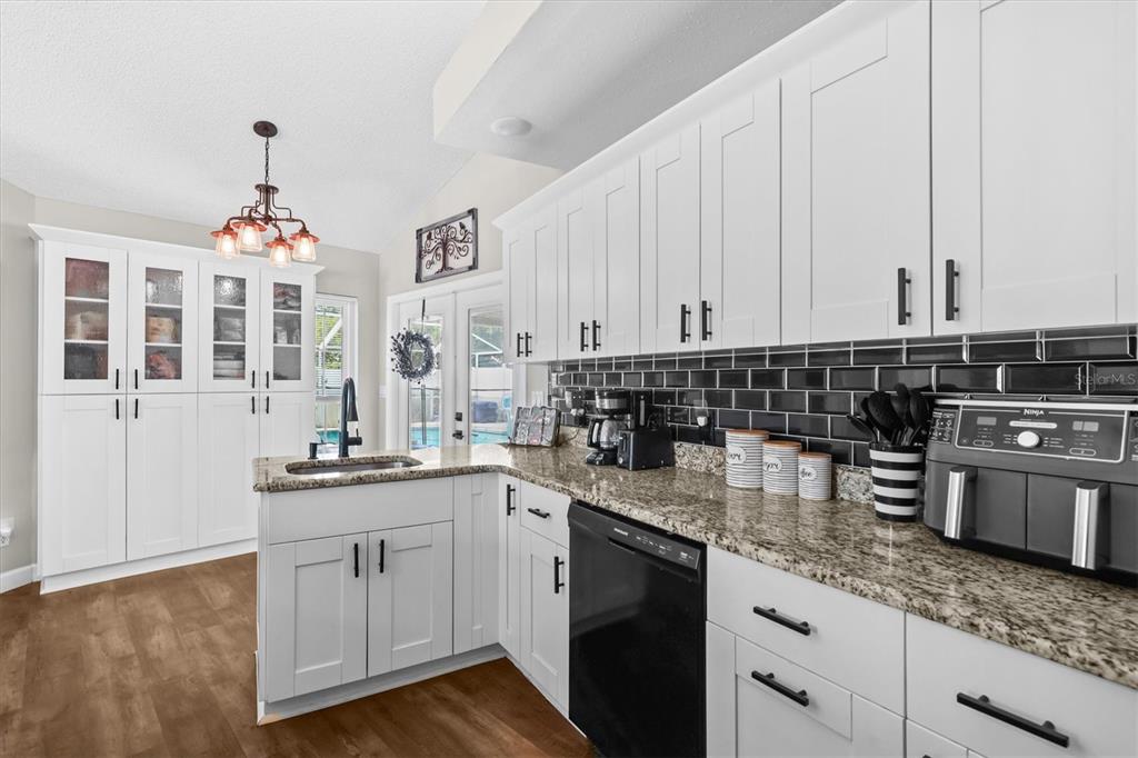 1049 Larkin Road Spring Hill, FL 34608 - Photo 24 of 64 a kitchen with stainless steel appliances granite countertop a sink stove and cabinets