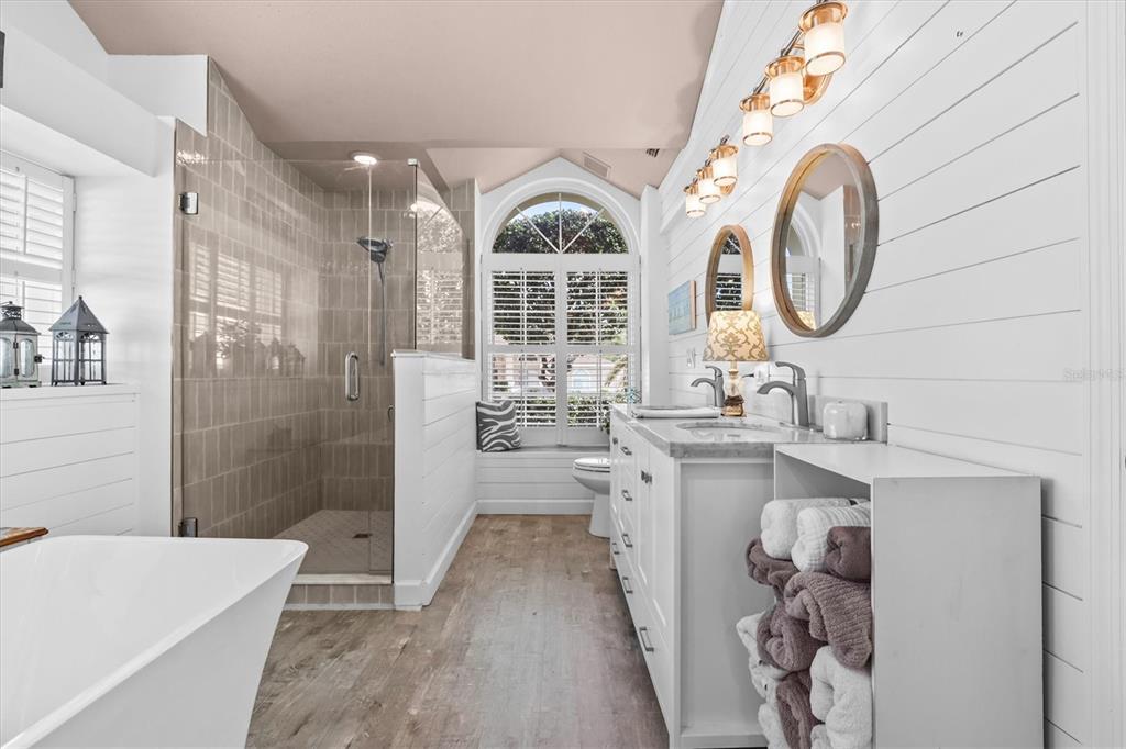 1049 Larkin Road Spring Hill, FL 34608 - Photo 34 of 64 a bathroom with a double vanity sink a mirror a bathtub and shower