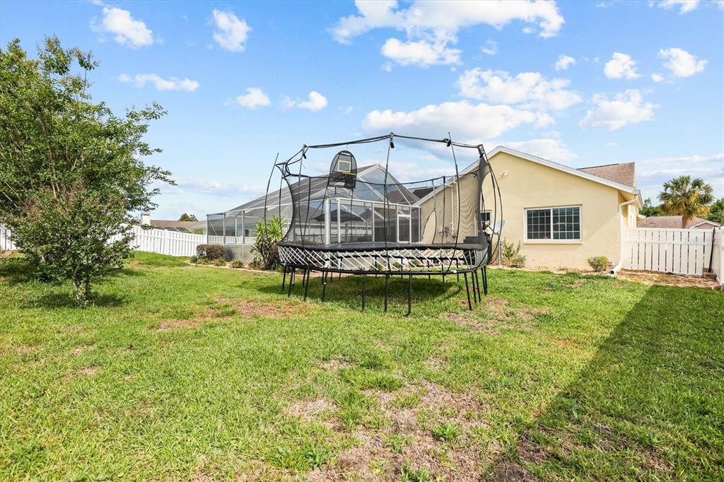1049 Larkin Road Spring Hill, FL 34608 - Photo 56 of 64 a view of a house with a big yard and potted plants