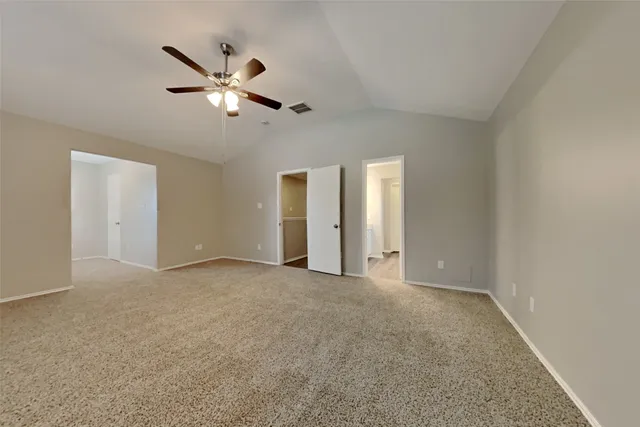 a view of an empty room with a ceiling fan