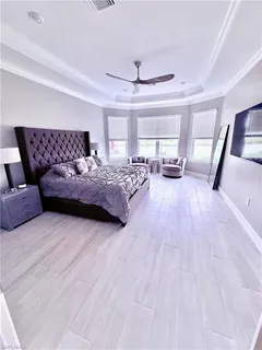 a bedroom with a large bed and a chandelier