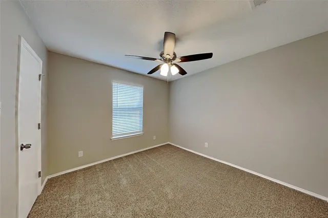 a view of a livingroom with a ceiling fan and window