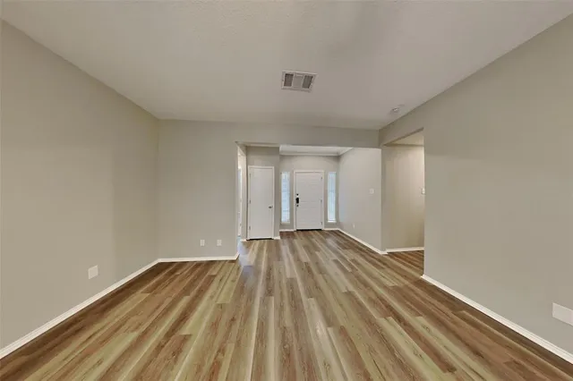 a view of an empty room and wooden floor