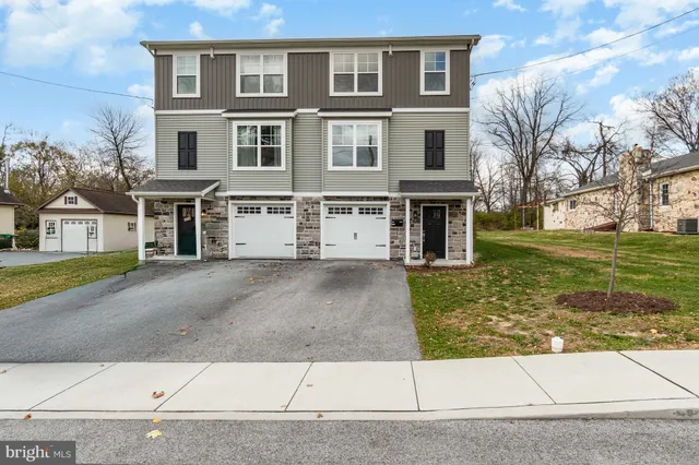 a front view of a residential apartment building with a yard