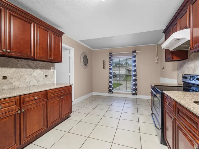 a kitchen with stainless steel appliances granite countertop a refrigerator and a stove top oven