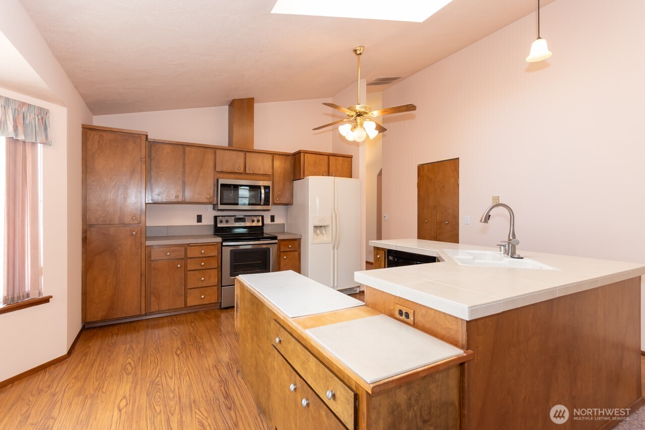 861 East Spruce Street Sequim, WA 98382 - Photo 11 of 39 a kitchen with a sink a counter top space stainless steel appliances and cabinets