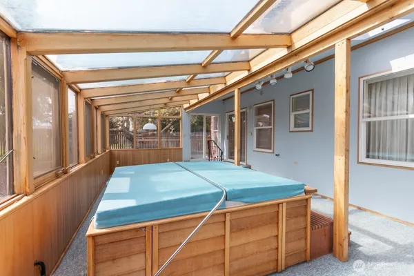 a room with pool table and windows