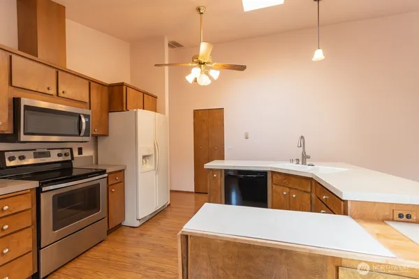 a kitchen with stainless steel appliances a stove a sink and a refrigerator