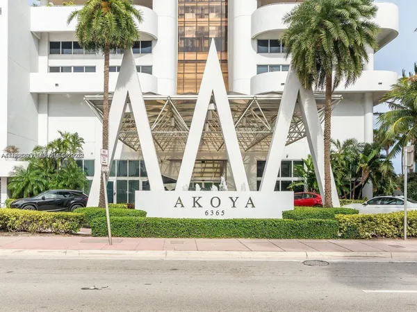 front view of house with a yard and palm trees
