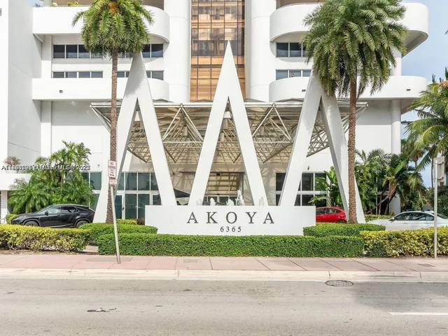 front view of house with a yard and palm trees