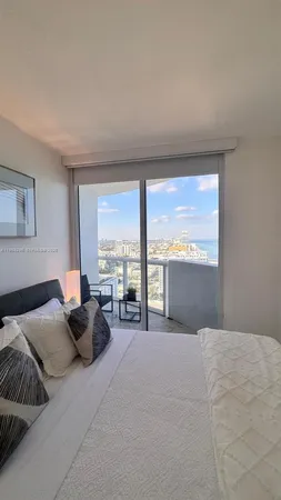 a spacious bedroom with a large bed and large windows