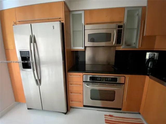 a kitchen with stainless steel appliances a refrigerator stove and microwave