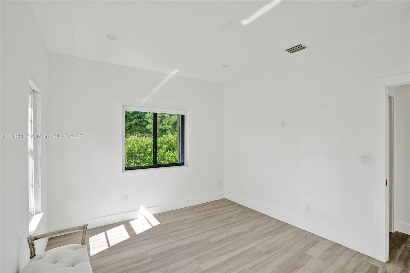 8371 Southwest 122nd Street Miami, FL 33156 - Photo 15 of 39 a view of an empty room with wooden floor and a window