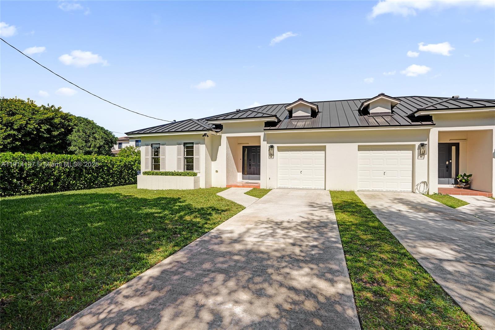 8371 Southwest 122nd Street Miami, FL 33156 - Photo 2 of 39 a front view of a house with a yard and potted plants