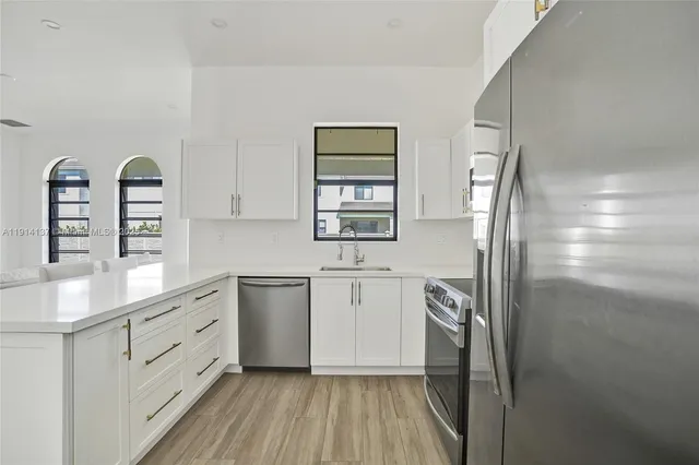 a kitchen with stainless steel appliances a refrigerator sink and stove