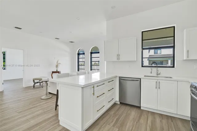 a kitchen with a sink cabinets and wooden floor