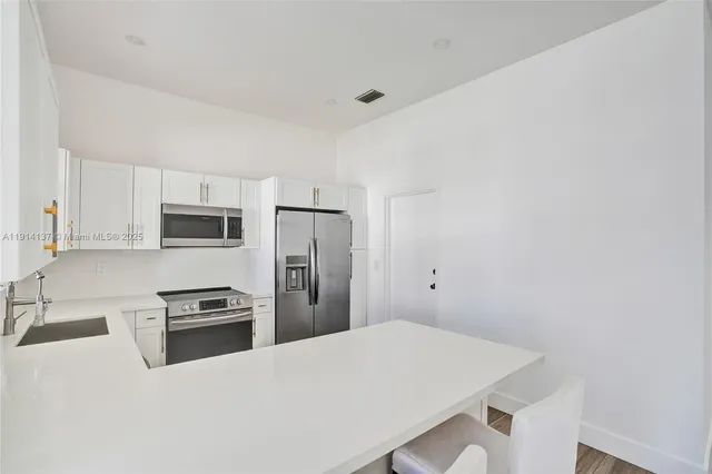 a kitchen with stainless steel appliances a refrigerator and a stove top oven