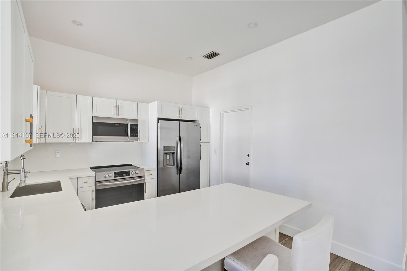 8371 Southwest 122nd Street Miami, FL 33156 - Photo 30 of 39 a kitchen with stainless steel appliances a refrigerator and a stove top oven