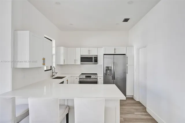 a kitchen with stainless steel appliances a refrigerator stove microwave and cabinets