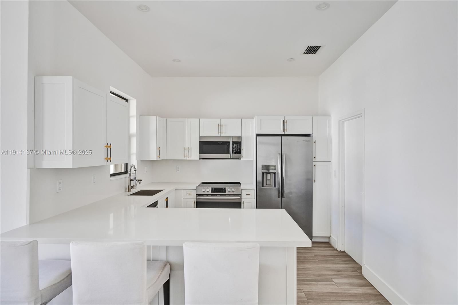 8371 Southwest 122nd Street Miami, FL 33156 - Photo 31 of 39 a kitchen with stainless steel appliances a refrigerator stove microwave and cabinets