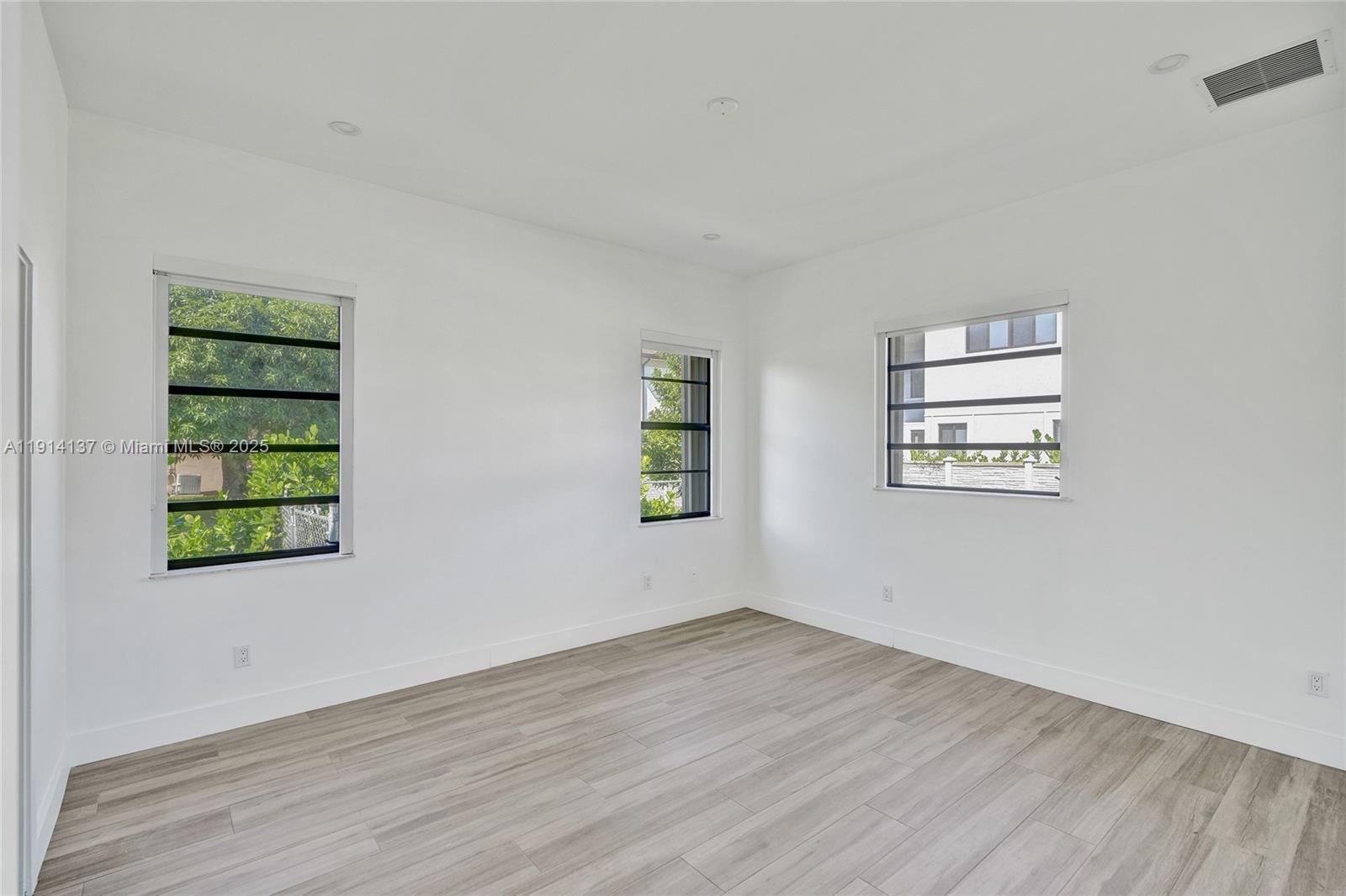 8371 Southwest 122nd Street Miami, FL 33156 - Photo 32 of 39 an empty room with wooden floor and windows