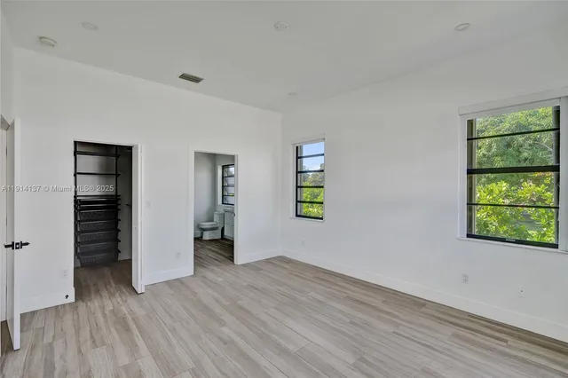 an empty room with windows and closet