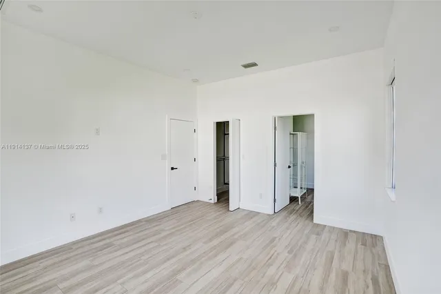 a view of a room with wooden floor and white doors