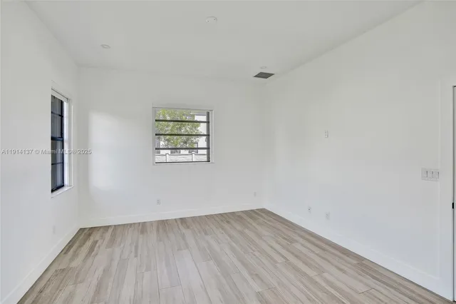 a view of a room with wooden floor and window