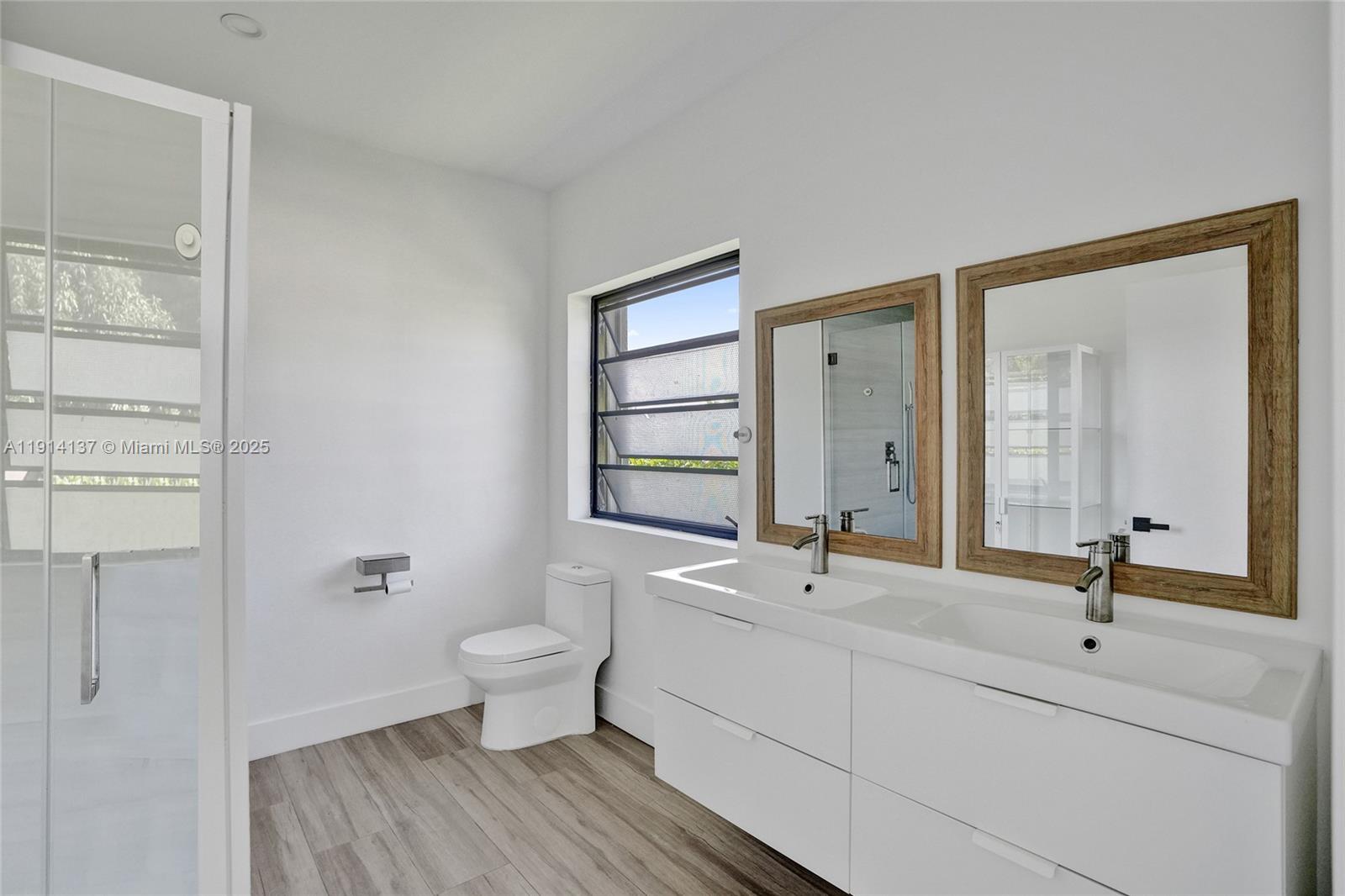 8371 Southwest 122nd Street Miami, FL 33156 - Photo 37 of 39 a bathroom with a double vanity sink toilet and a mirror