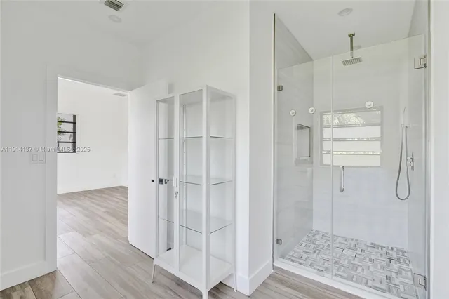 a bathroom with a glass shower door