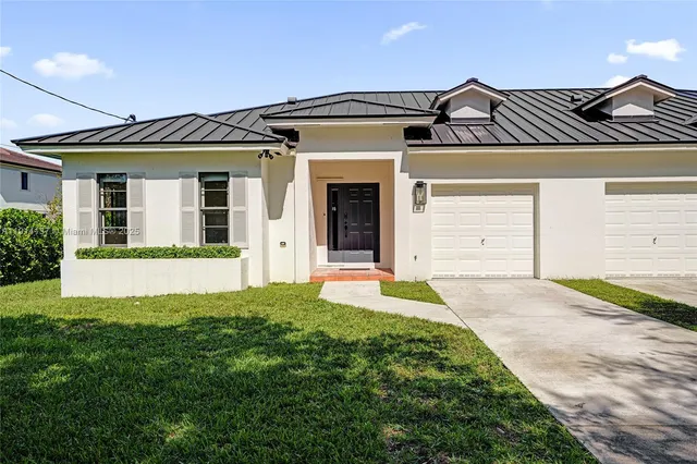 a front view of a house with a garden and plants
