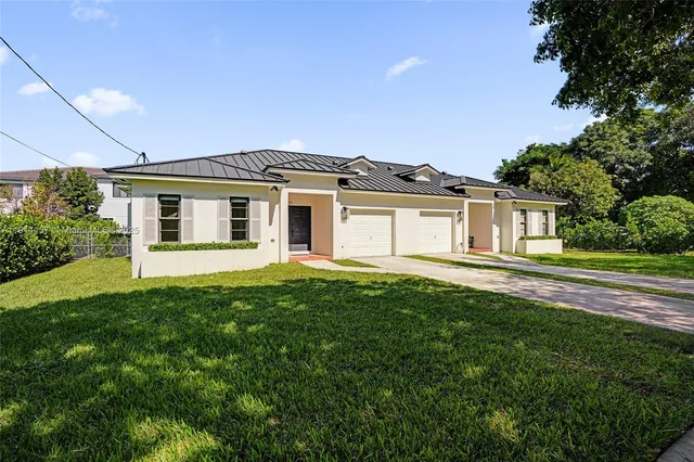 a front view of a house with a garden