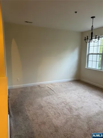 an empty room with windows and ceiling fan