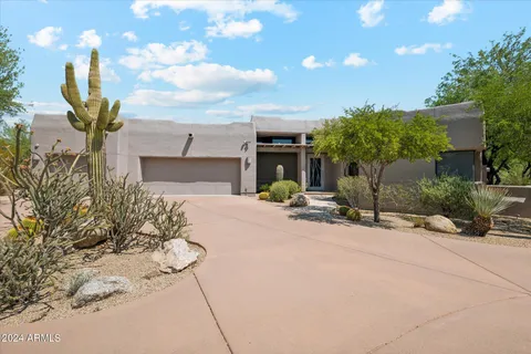 a front view of a house with a yard and potted plants