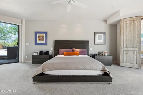 a large bed sitting in a bedroom next to a window with lamp