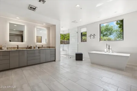 a bathroom with a tub a sink and mirror