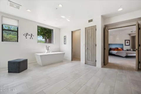 a bathroom with a tub shower and mirror