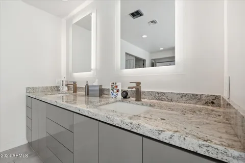a bathroom with a granite countertop sink and a mirror