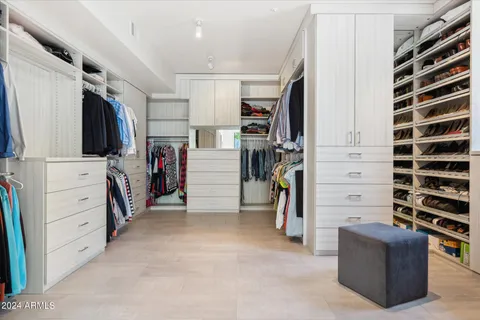 a view of walk in closet with clothes and shoes
