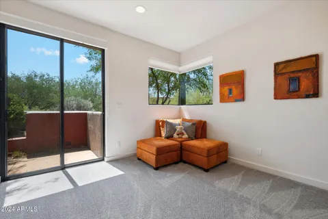 a living room with furniture and a floor to ceiling window