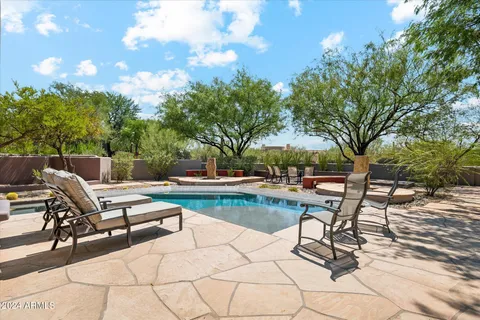 a view of a swimming pool with lounge chairs in patio