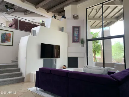 a living room with furniture a flat screen tv and a fireplace
